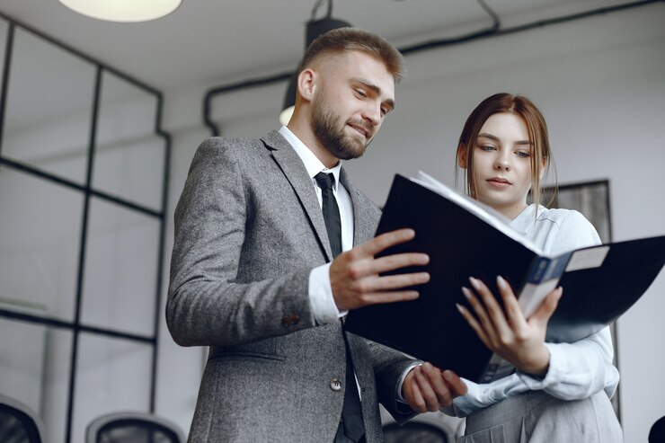 Two colleagues reviewing a document together in an office setting.