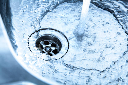 Running water in a sink with a modern drain, illustrating water-saving technologies in Binghatti Hills.